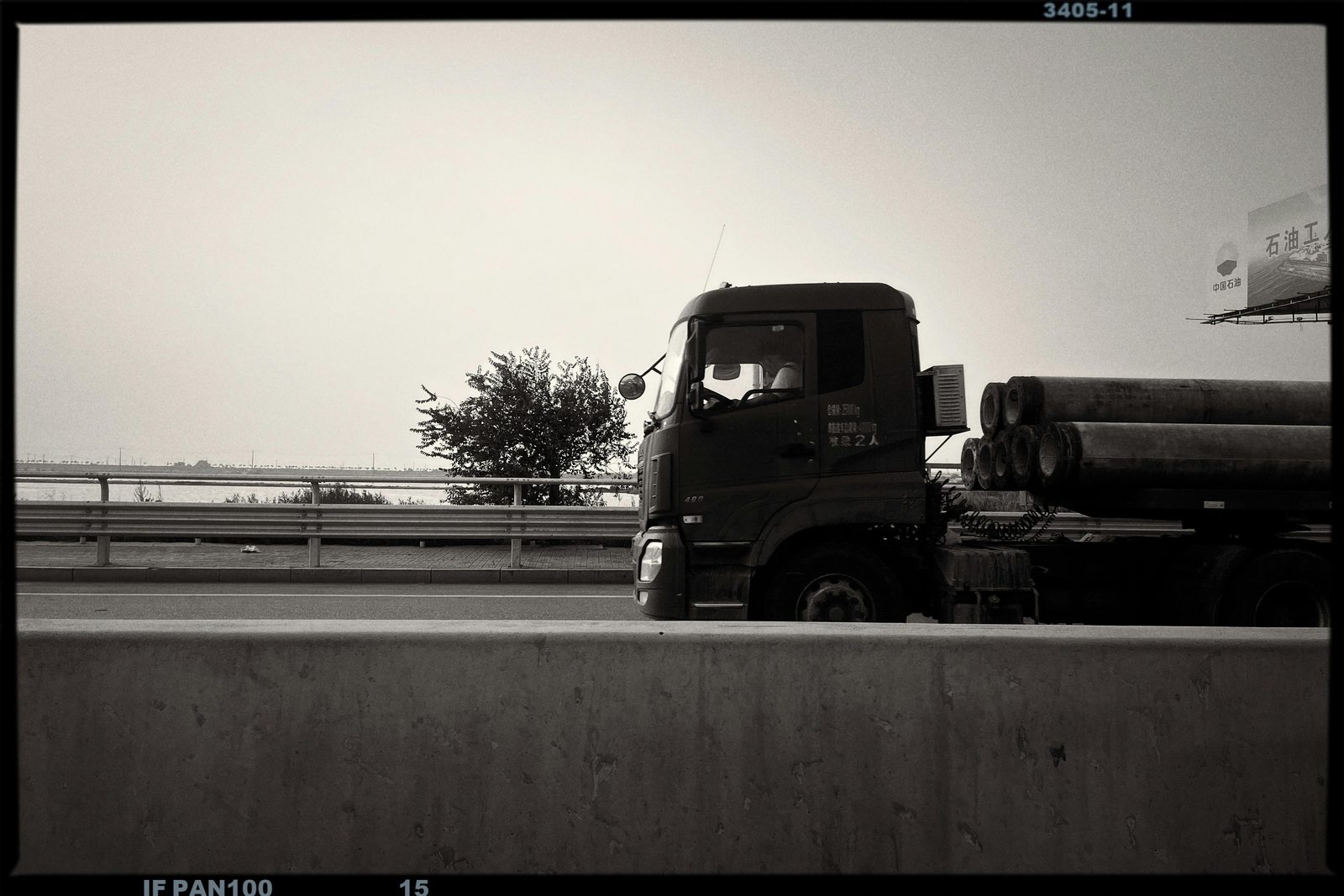 A tractor-trailer travelling on a multi-lane highway in daylight traffic