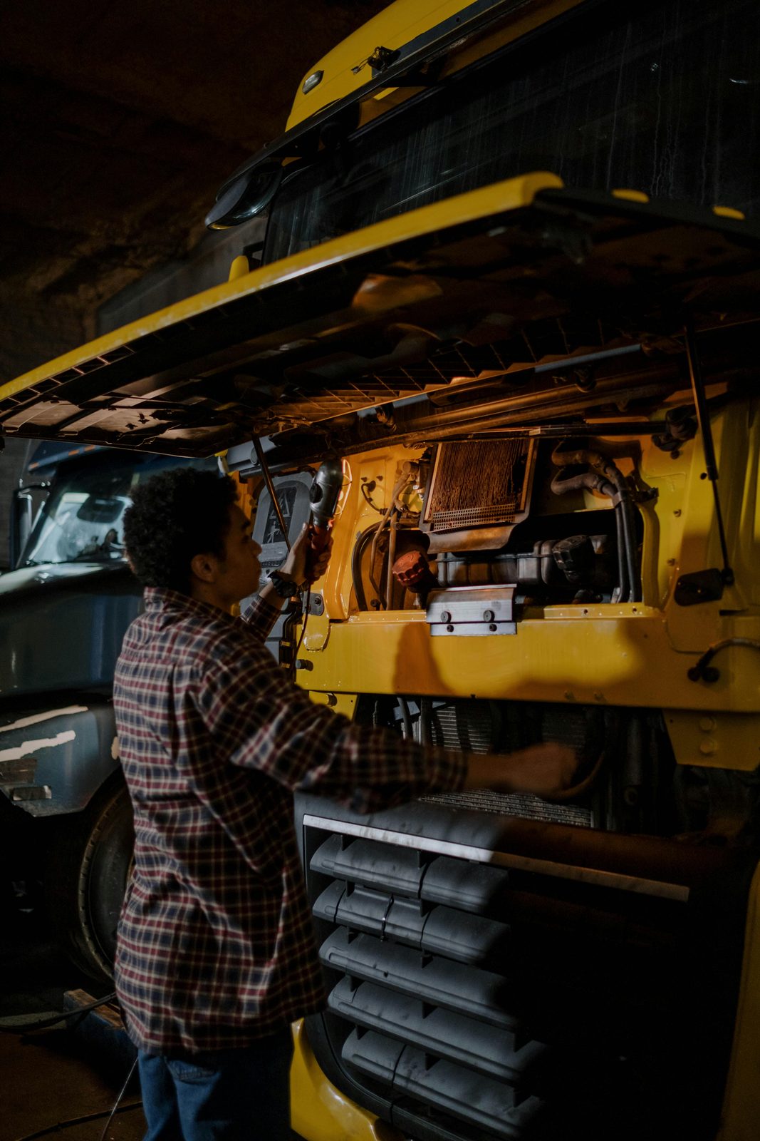 An inspector examining the undercarriage and brake components of a commercial truck